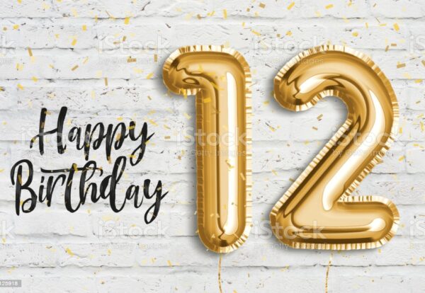 Happy 12th birthday gold foil balloon greeting white wall background. 12 years anniversary logo template- 12th celebrating with confetti. Photo stock.